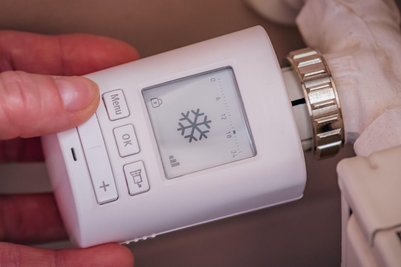 Main qui regle un thermostat de radiateur pour economiser l energie en hiver