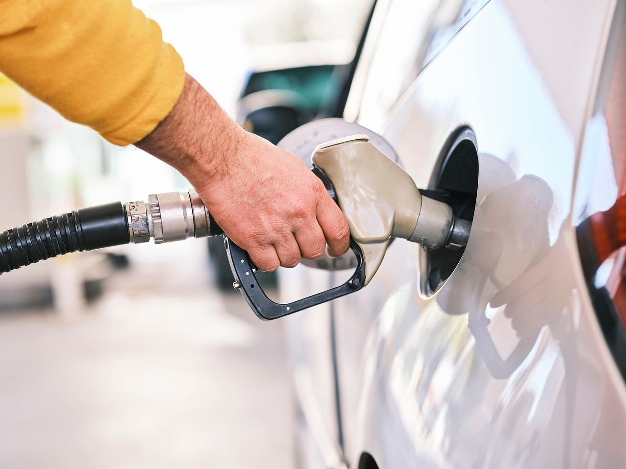 Main tenant le pistolet pour faire le plein de carburant d une voiture