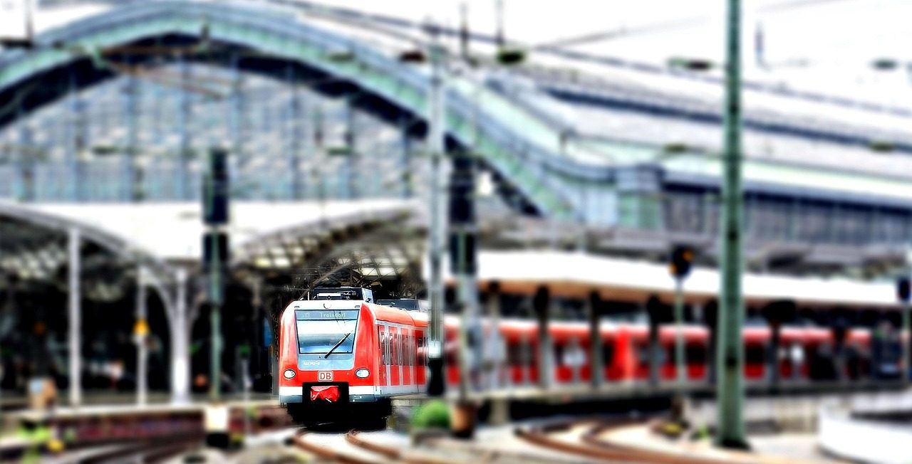 Gare avec train à quai sous une verrière
