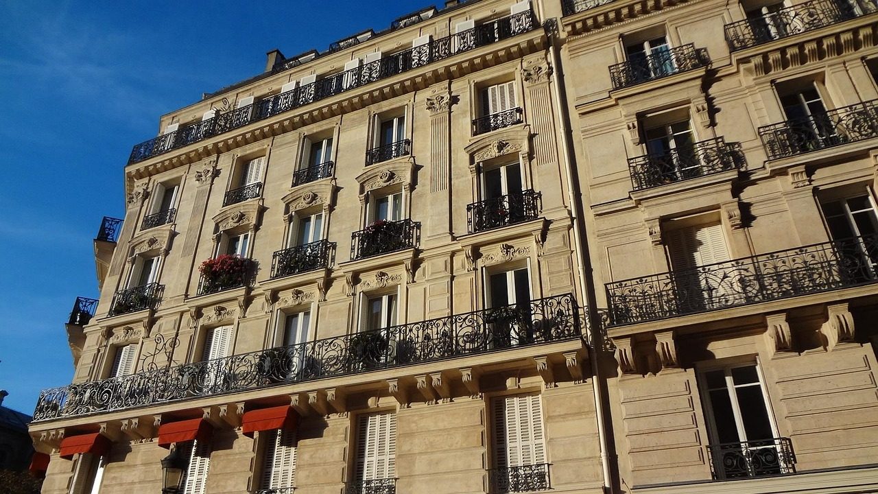 Façade d'immeuble haussmannien à Paris avec balcons en fer forgé