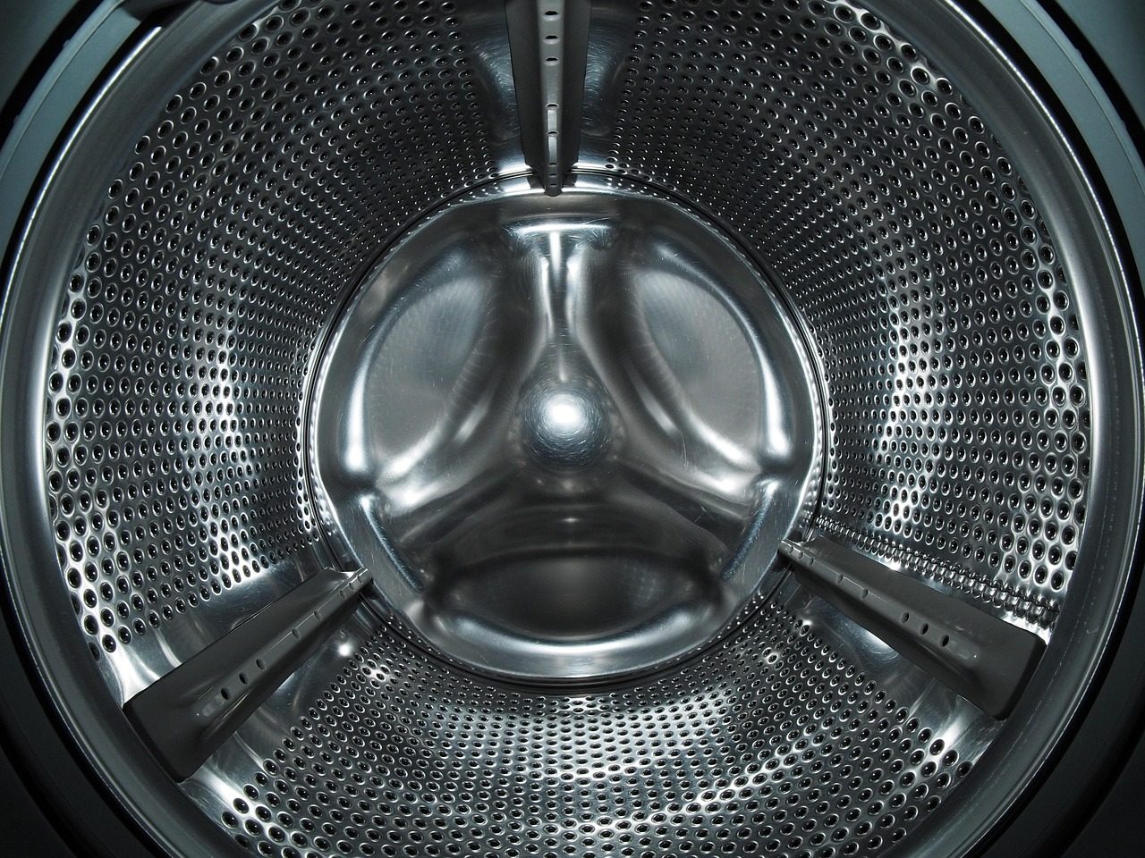 Doudoune posée dans le tambour d'un lave-linge frontal, programme synthétique