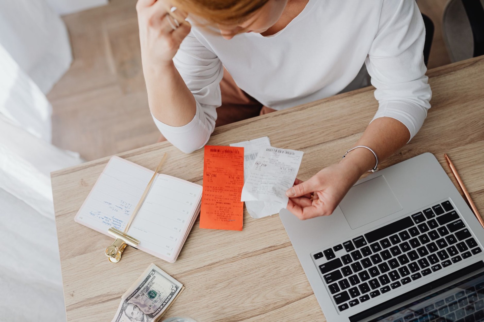 Ordinateur portable et reçu papier posés sur un bureau, pour préparer une quittance de loyer mensuelle