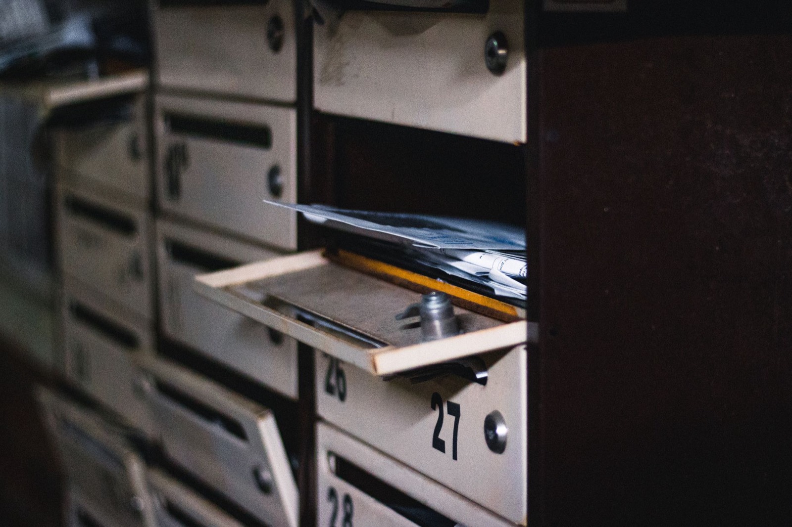 Porte d'appartement et boîtes aux lettres dans un hall d'immeuble, où l'on dépose parfois la quittance de loyer papier