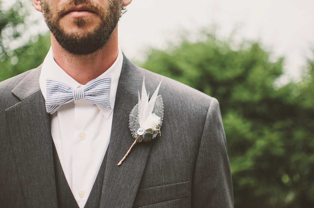 costume clair gris clair porté lors d'une cérémonie de mariage en plein jour d'été